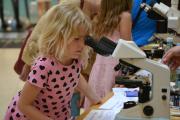 väike laps vaatab mikroskoopi